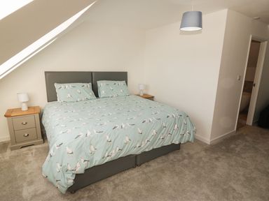 A bedroom with a bed and nightstands at Cae Mawr Caernarfon