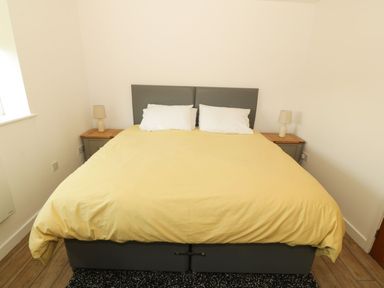A bedroom with a bed and nightstands at Cae Mawr in Caernarfon