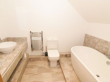 A bathroom with a sink, toilet, and bathtub at Cae Mawr in Caernarfon