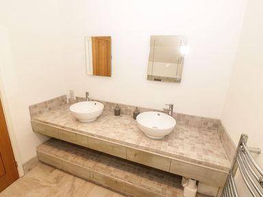 A bathroom with two sinks and mirrors at Cae Mawr in Caernarfon