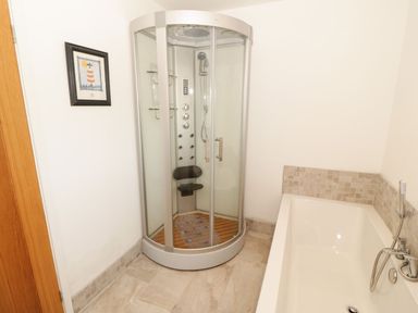 A bathroom with a shower and bathtub at Cae Mawr in Caernarfon