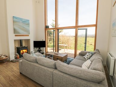 A living room with a sofa and fireplace at Cae Mawr in Caernarfon