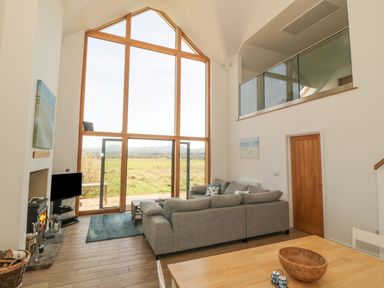 A living room with a sofa and television at Cae Mawr in Caernarfon