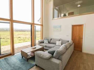 A living room with a sofa and coffee table at Cae Mawr in Caernarfon