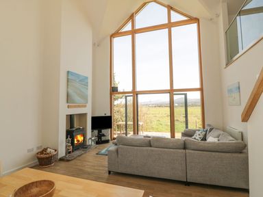 A living room with a sofa and a television at Cae Mawr in Caernarfon