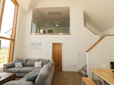 A living room with a sofa and a table at Cae Mawr in Caernarfon