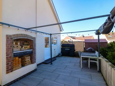 An outdoor area with a seating arrangement and a fireplace at Cae Mawr Dinas Dinlle