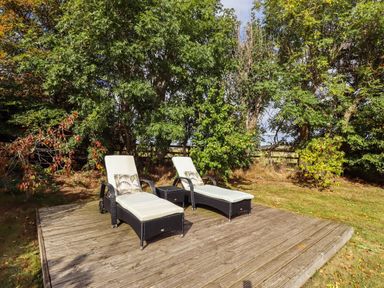 An outdoor area with sun loungers on a wooden deck at The Gables in Alnwick