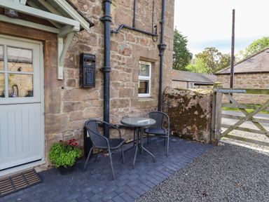 An outdoor seating area with a table and chairs at The Gables in Alnwick