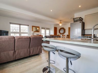 A living room with a sofa and kitchen counter at Apartment 3 Newquay