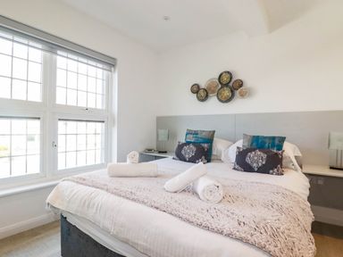 A bedroom with a double bed and decorative pillows at Apartment 3 in Newquay