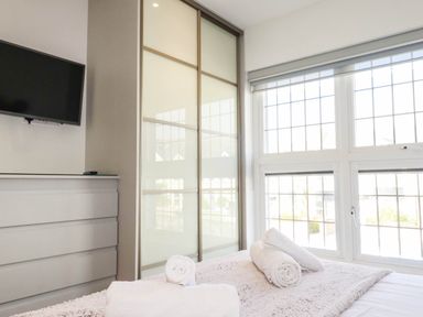 A bedroom with television and windows at Apartment 3 in Newquay