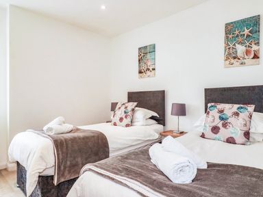 A bedroom with two beds and wall art at Apartment 3 in Newquay