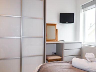 A bedroom with a desk and a television at Apartment 3 in Newquay