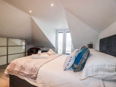 A bedroom with a bed and a wardrobe at Apartment 3 in Newquay