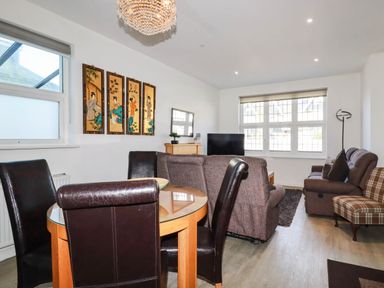 A living room with a dining area and furniture at Apartment 1 in Newquay