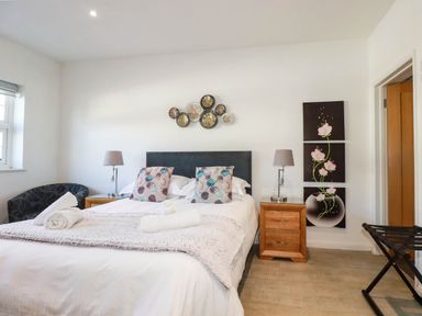 A bedroom with a bed and bedside tables at Apartment 1 in Newquay