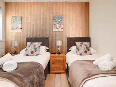A bedroom with twin beds and wall art at Apartment 1 in Newquay