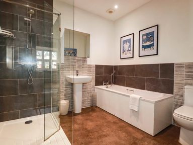 A bathroom with a shower and bathtub at Apartment 1 in Newquay