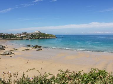 A beach with people and buildings in the background at Apartment 1 in Newquay