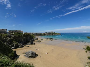A beach with water and rocks at Apartment 1 in Newquay