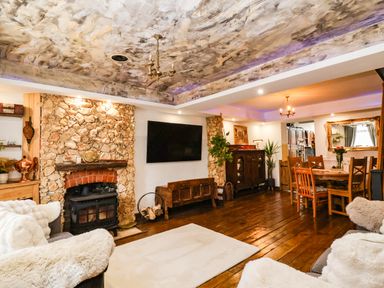 A living room with a fireplace and wooden table at Severnwolf House in Gloucester