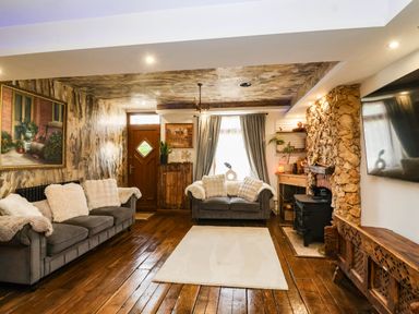 A living room with a sofa and fireplace at Severnwolf House in Gloucester