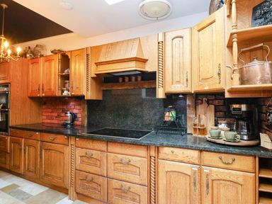 A kitchen with wooden cabinets and countertop at Severnwolf House in Gloucester