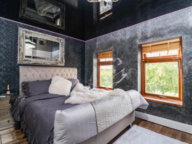 A bedroom with a bed and windows at Severnwolf House in Gloucester