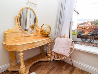A vanity table with a mirror and a globe with a chair at Severnwolf House in Gloucester