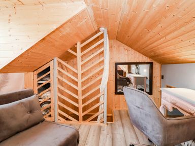 An attic space with a sofa, desk, and decorative shelving at Severnwolf House in Gloucester