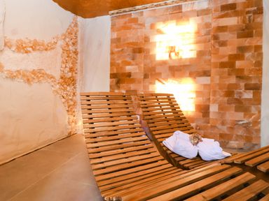A spa room with wooden lounge chairs and salt wall at Severnwolf House in Gloucester