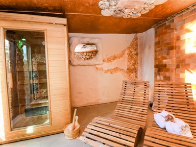 A sauna with wooden benches and a salt wall at Severnwolf House in Gloucester