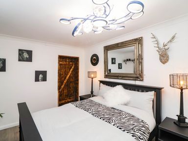 A bedroom with a bed and decorative wall features at Severnwolf House in Gloucester