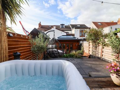 A garden with a hot tub and hanging chair at Severnwolf House in Gloucester