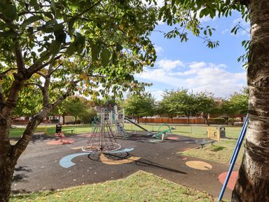 A playground with play structures and swings at Severnwolf House in Gloucester