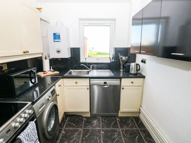 A kitchen with appliances and a window at 21 Ferrara Square Swansea