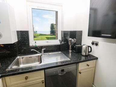 A kitchen with sink and appliances at 21 Ferrara Square Swansea