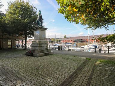 A statue near the water with boats at 21 Ferrara Square Swansea