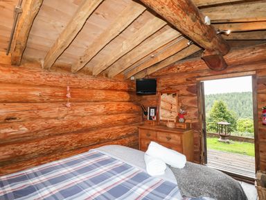 A bedroom with a bed and a dresser at Thimble Lodge in Gunnislake