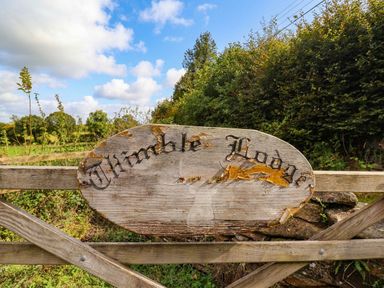 A wooden sign at the entrance of Thimble Lodge in Gunnislake