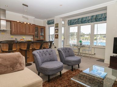 A living room with kitchen area and seating at 1 Embankment House Dartmouth