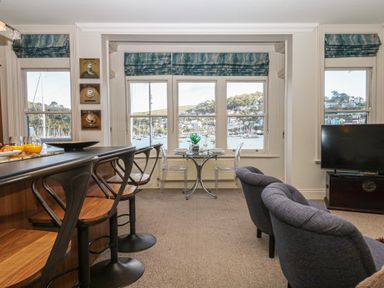 A living room with a bar counter and dining table at 1 Embankment House in Dartmouth