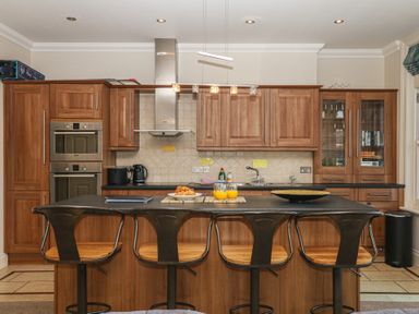 A kitchen with wooden cabinets and an island at 1 Embankment House in Dartmouth