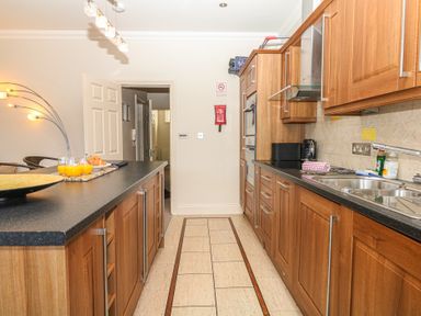 A kitchen with wooden cabinets and countertop at 1 Embankment House in Dartmouth