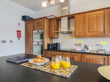 A kitchen with orange juice and croissants at 1 Embankment House in Dartmouth