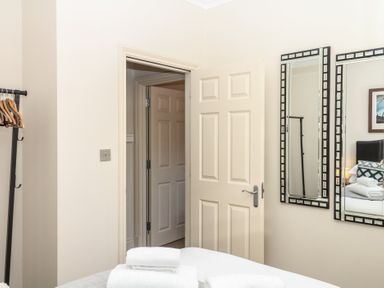 A bedroom with a door and mirrors at 1 Embankment House Dartmouth