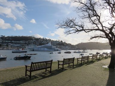A view of a river with benches and boats at 1 Embankment House in Dartmouth
