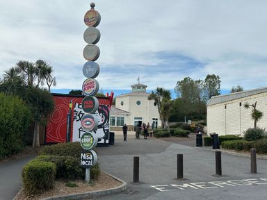 A building with a signpost and people outside at Club Sahara in Sandy Bay, Exmouth