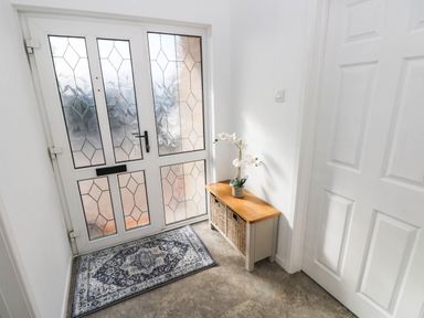 A hallway with a door and a storage bench at 24 Little Castle Grove Hubberston